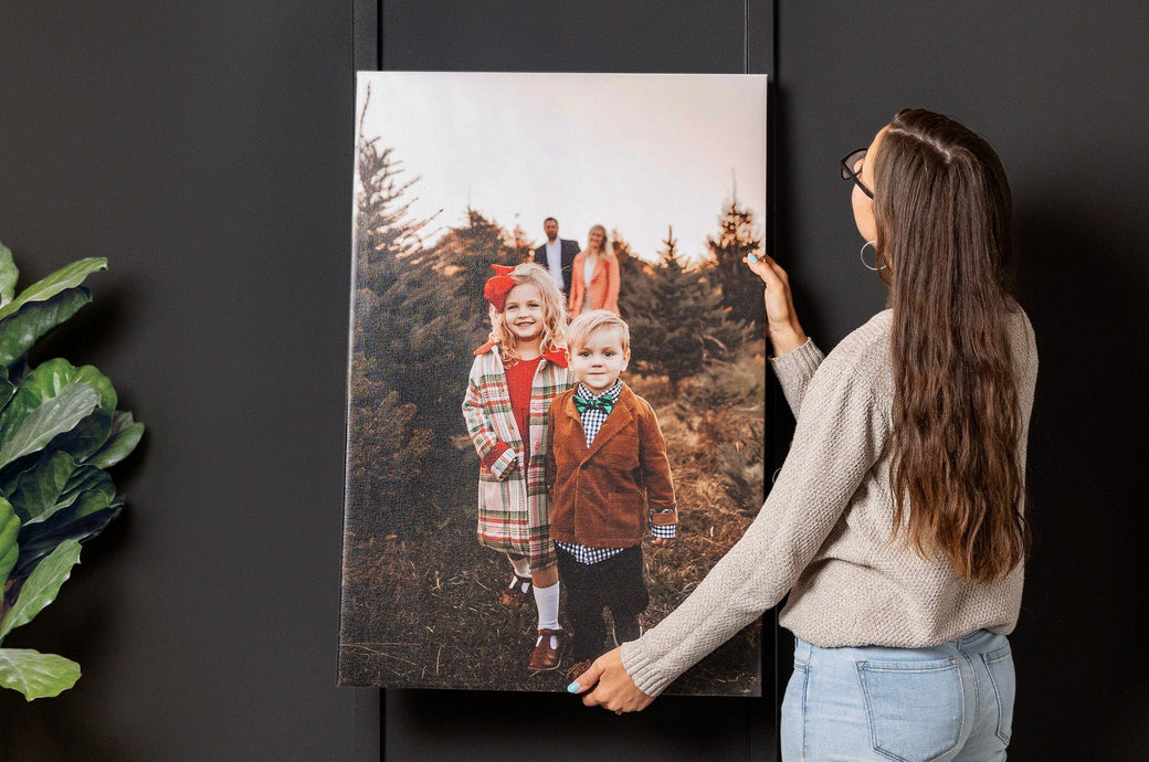 Woman holding up a christmasy 24x36" Premium Canvas to hang on a wall.