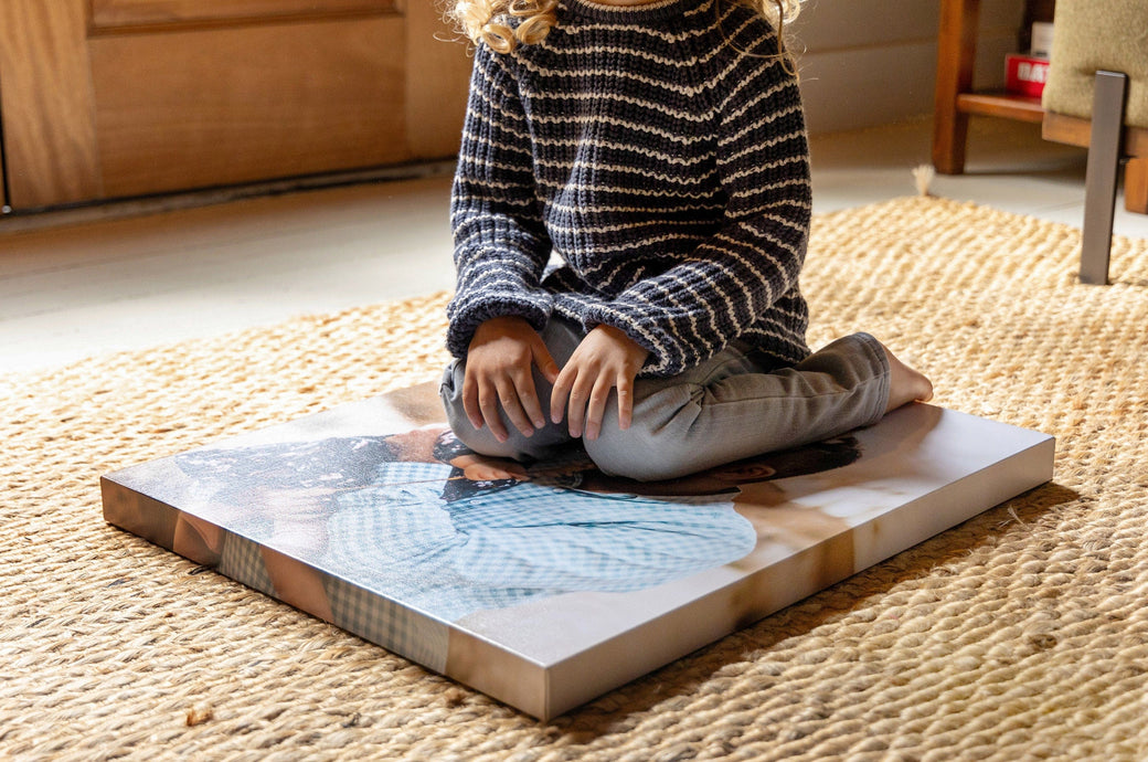 Child sitting on a 20x24" Premium Canvas to demonstrate how the canvas has a solid backing. 