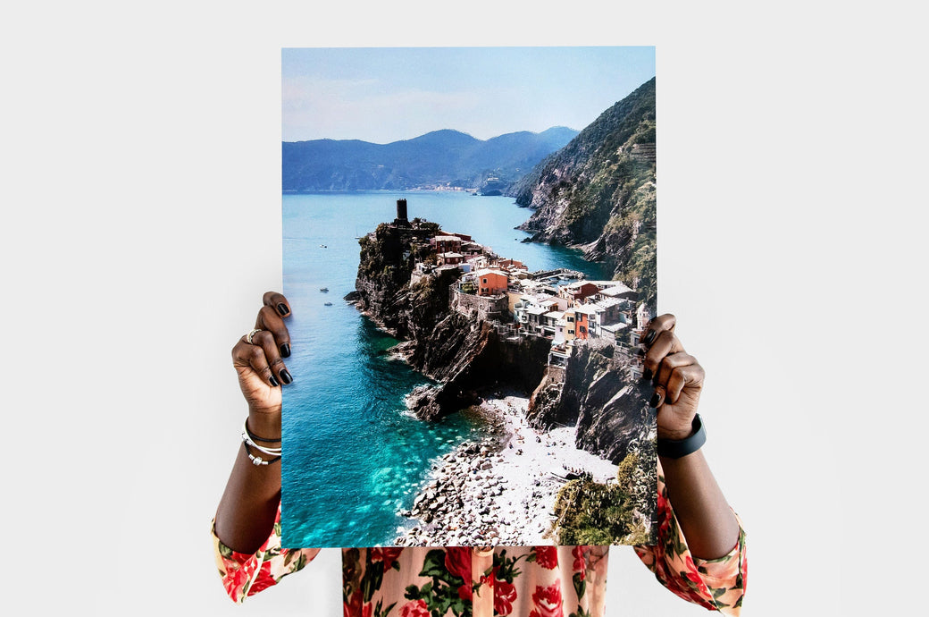 Woman holding a 18x24" Photo Print featuring a picture of a coastal town. 