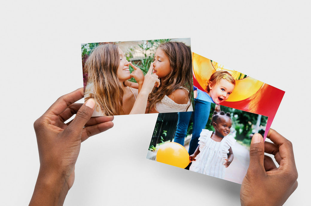 Woman holding 3 4x6" Photo Prints featuring pictures of small children. 