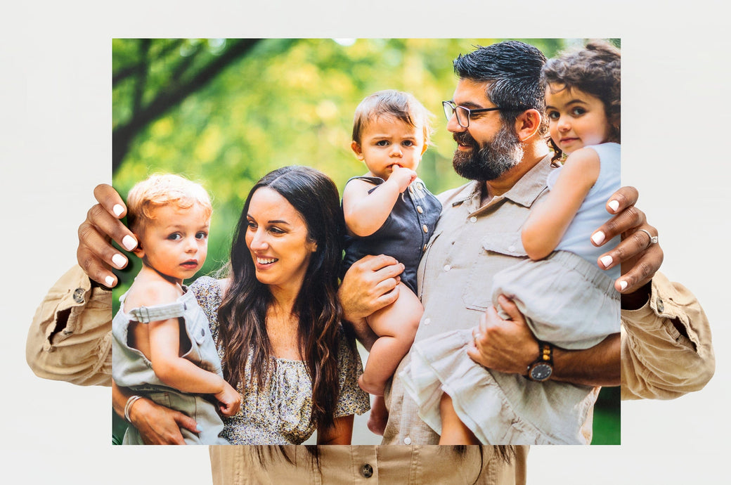 Woman holding up a 16x20" Landscape Lustre Photo Print with a picture of a family with three small children - Nations Photo Lab